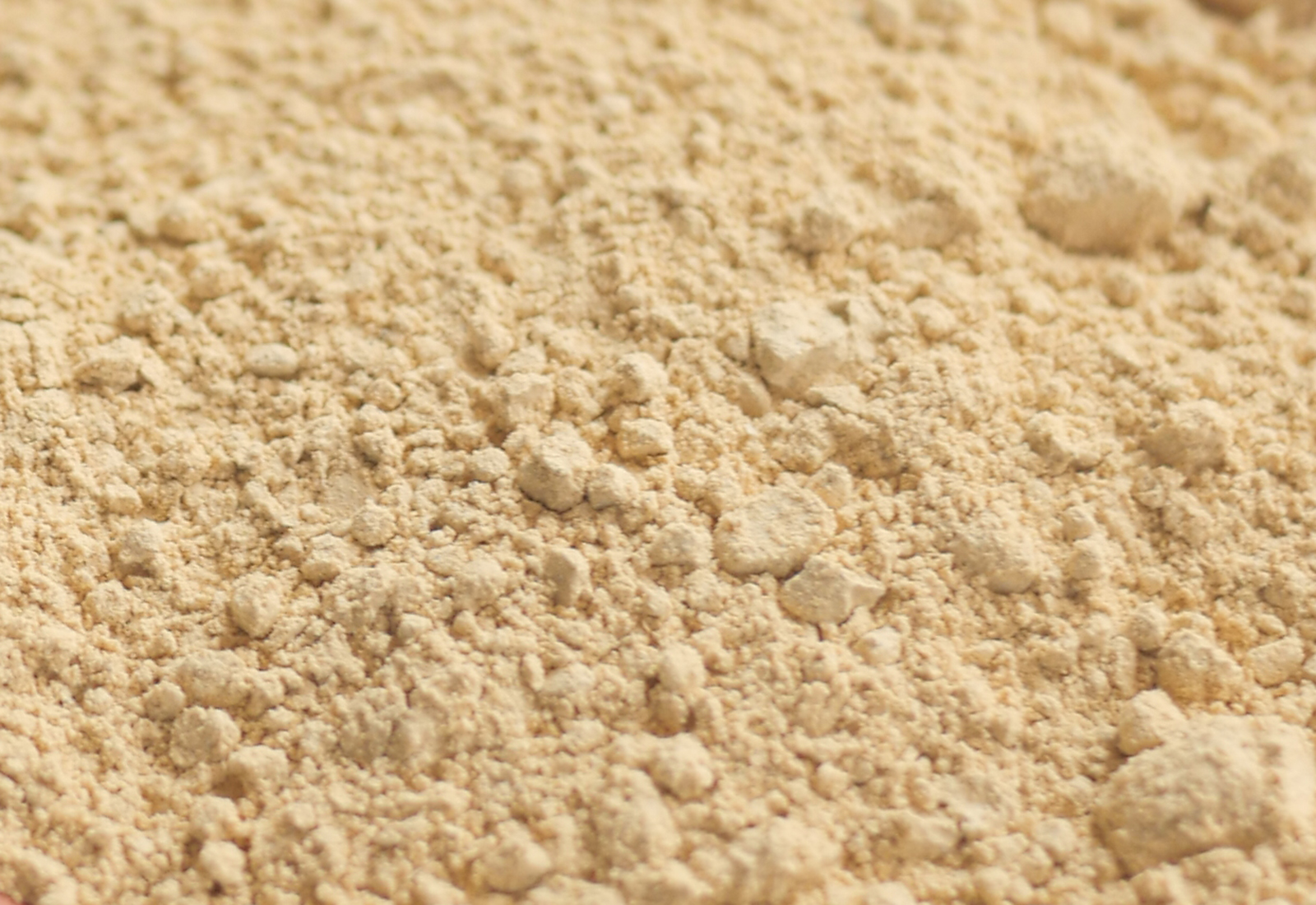 mixing brewers yeast flakes in a container on table .